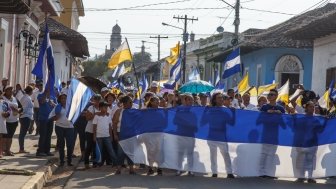 Granada, Nicaragua - May 29, 2018: peaceful protests in Granada Nicaragua for reform of INSS, people flying the Nicaraguan flag