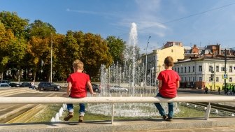  boys sit and look at the fountain in the center of Kharkiv, Ukraine