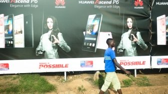 Kampala Uganda on January 23, 2018: people walking past mobile phone advertisement