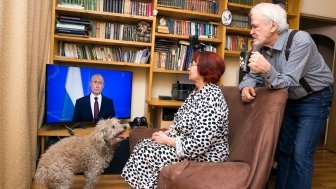 Russian pensioners watch Vladimir Putin's presidential address on television