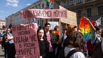 Protesters with the poster "One woman dies every hour of domestic violence in Russia."