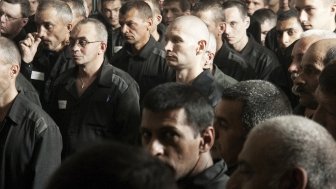 Large group of men in prisoner clothing 