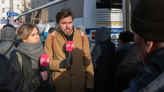 Image of two reporters with microphones 