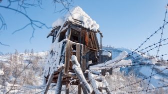 Ruins of wooden prison observation tower of labour camp GULAG in Verkhoyansk Range in Yakutia during cold winter day, Russia. The construction of the Kolyma highway aka Road of bones