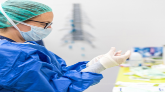 Covid-19. Female nurse puts on protective gloves. Personal protective equipment in the fight against Coronavirus disease .