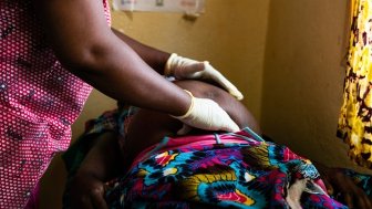 African woman doctor examining a pregnant patient