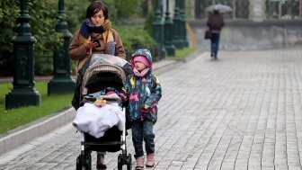 A mother and child walk down the street in Russia, October 2020