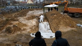 Forensic experts are working to dig up bodies from a clandestine grave found behind a church in the town of Bucha.