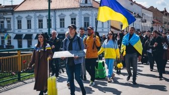 Protesters walking down street with Ukrainian Flags