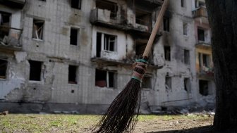 Broom in foreground, bombed building in background