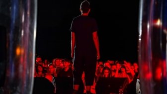 Image of person on stage with audience in the background 