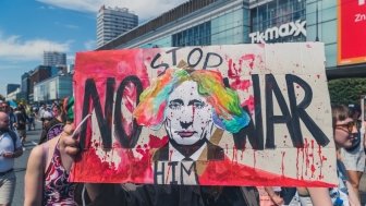 Sign at Polish protest depicting Putin as a clown with the caption "Stop Him--No War"