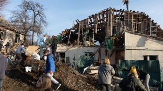 Volunteers clear and dismantle debris at the site of a Russian missile attack on December 31