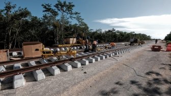 Workers install rails for the Mayan Train in Section 4