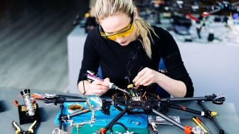 A woman engineer working on a racing drone.