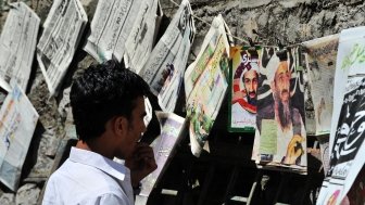 Man looking at Newspapers with Bin Laden's Photo