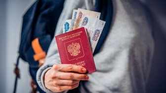 Tourist holds Russian passport and Russian roubles