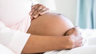 Pregnant woman holding her abdomen 