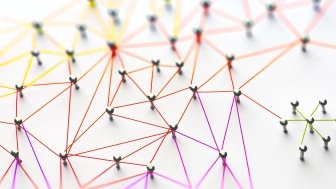 Linking entities. Networking, social media, SNS, internet communication abstract. Small network connected to a larger network. Web of red, orange and yellow wires on white background.