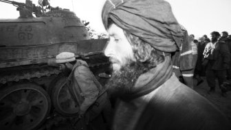 B&w photo of a man in front of tank