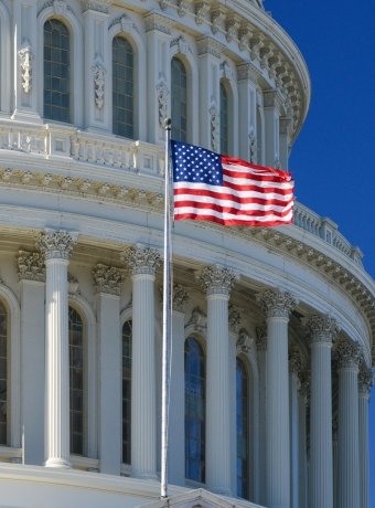 US Capitol Building dome detail with waving national flag - Washington DC, United States of America