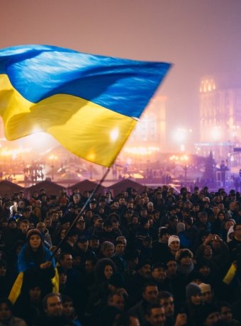 Meeting on the Independence square at night in Kiev. Girl holding a flag of Ukraine. During revolution to support the integration of Ukraine into the European Union.