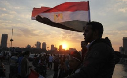 People stand on a bridge overlooking the river Nile.