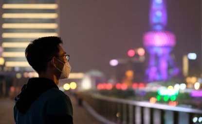 A young man wearing surgical mask looking at Oriental Pearl TV Tower in Shanghai at night