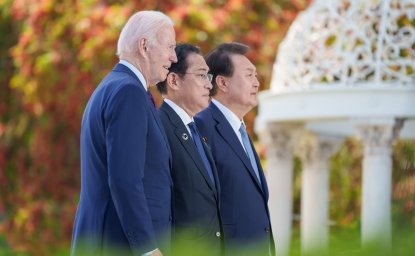 President Biden, Prime Minister Kishida, and President Yoon standing together outside looking off camera.