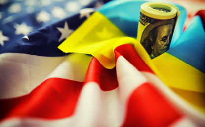 American and Ukrainian flags with a roll of American dollars