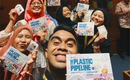 Indonesian students and educators taking a selfie with the plastic pipeline brochures and sticker