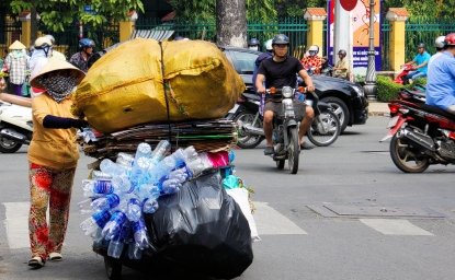 A person pushing a cart of plastic waste