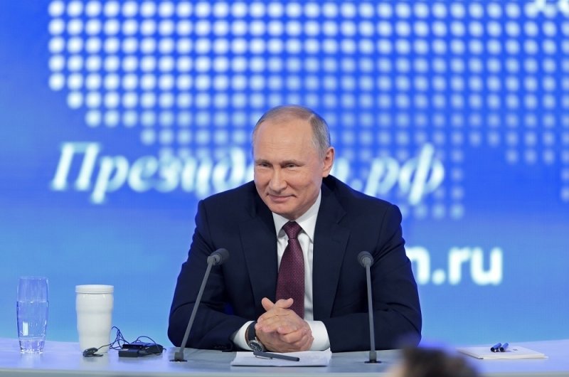 Image of Vladimir Putin smiling while taking questions