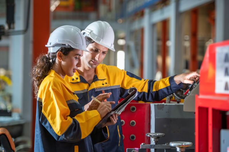 Two factory employees work together onsite