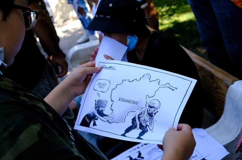 A protester holds a placard during a demonstration of members of the Afghan community outside the US embassy in Athens after the Taliban swept to power in Afghanistan on August 28, 2021