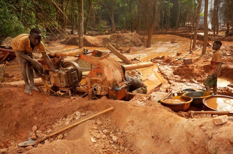 Assafo, Ivory Coast - April 3, 2024: children feeding a crusher with ore to extract some grams of gold. In Ivory Coast, children from Burkina Faso often provide cheap manpower for local businessmen