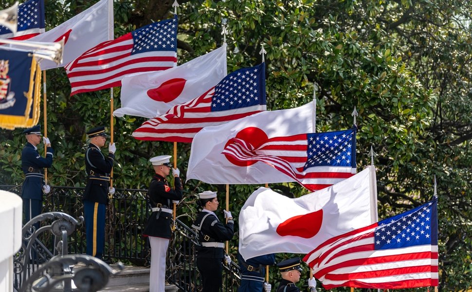 A row of soldiers holding flags, alternating between the US and Japanese flags.