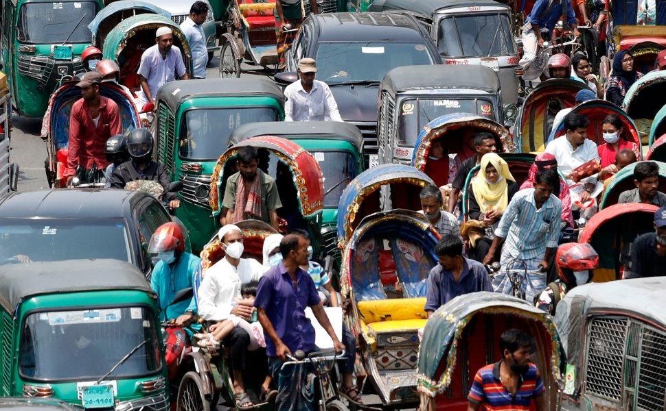 A crowded street full of traffic including cars and rickshaws.