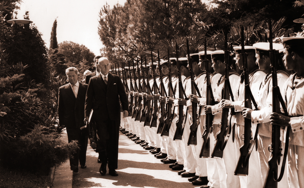 George F. Kennan stands before a line of soldiers