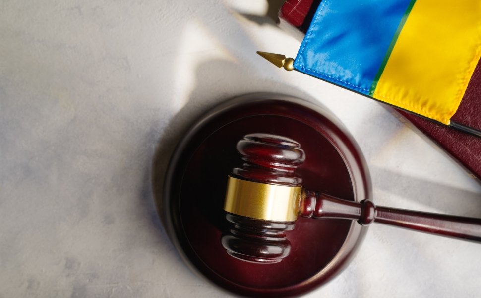 A gavel on a desk next to a Ukrainian flag