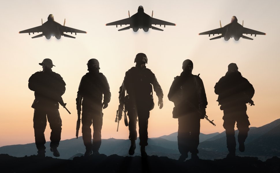 Soldiers walking away from camera with planes overhead