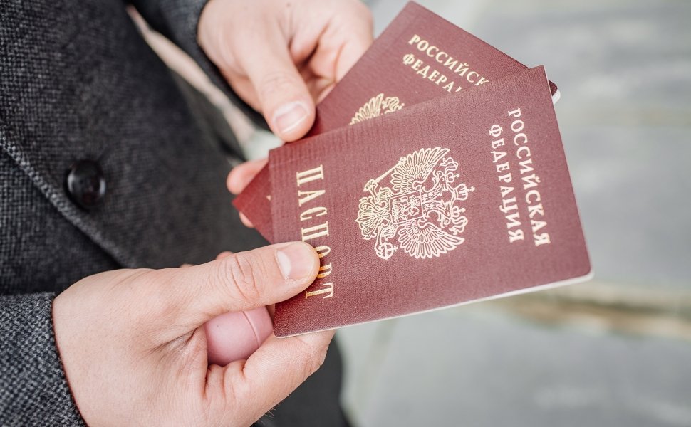 Two russian passports in hand. Russian official document on outdoor background