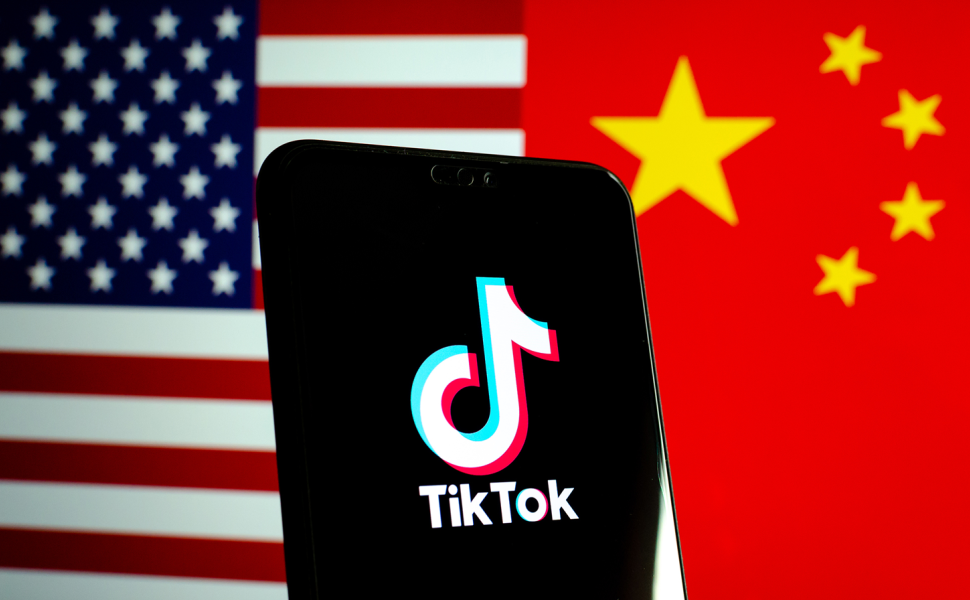 October 25 2019: TikTok app logo on a smartphone screen and flags of China and United States. Tiktok WeChat are banned. Apps are in centre of US - China tensions and security concerns.