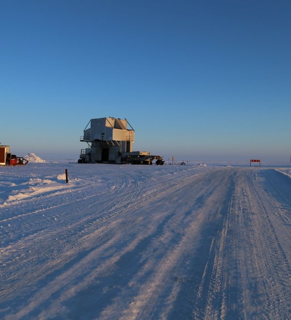 Snow road with a substructure of the oil work over rig and a distant view of the drilling rig at an oilfield in the tundra in winter. Source: Shutterstock