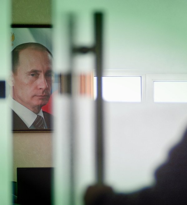 Image of Vladimir Putin behind closing door