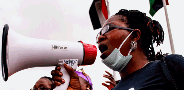 Women trying to make their voices heard using a megaphone