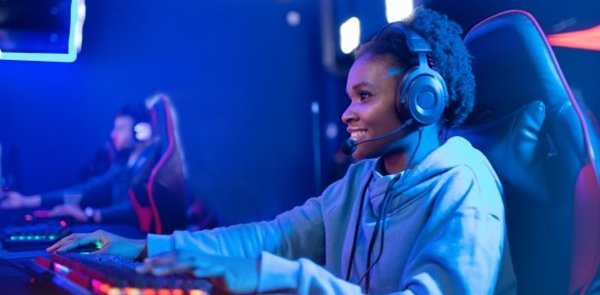 Portrait Streamer African young woman professional gamer playing online games computer, neon color.