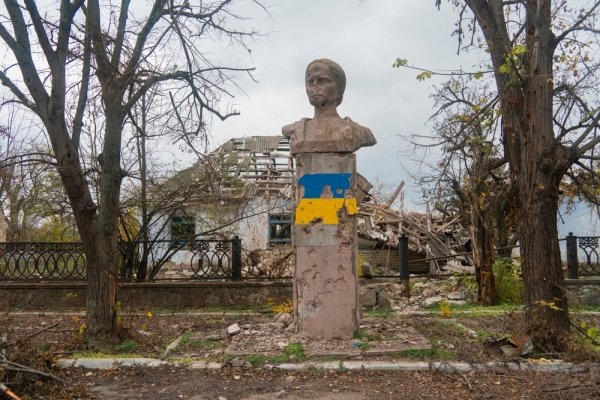 War in Ukraine. 2022 Russian invasion of Ukraine. A monument damaged by shelling against the background of a destroyed house. Terror of the civilian population. War crimes