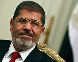 Egypt's first Islamist president Mohamed Mursi attends during his meeting with Turkish Foreign Minister Ahmet Davutoglu at the presidential palace in Cairo July 2, 2012. Egypt will approach the International Monetary Fund (IMF) and other financial institutions to help get its economy back on track once Mursi appoints a government, one of his financial advisers told Reuters. 