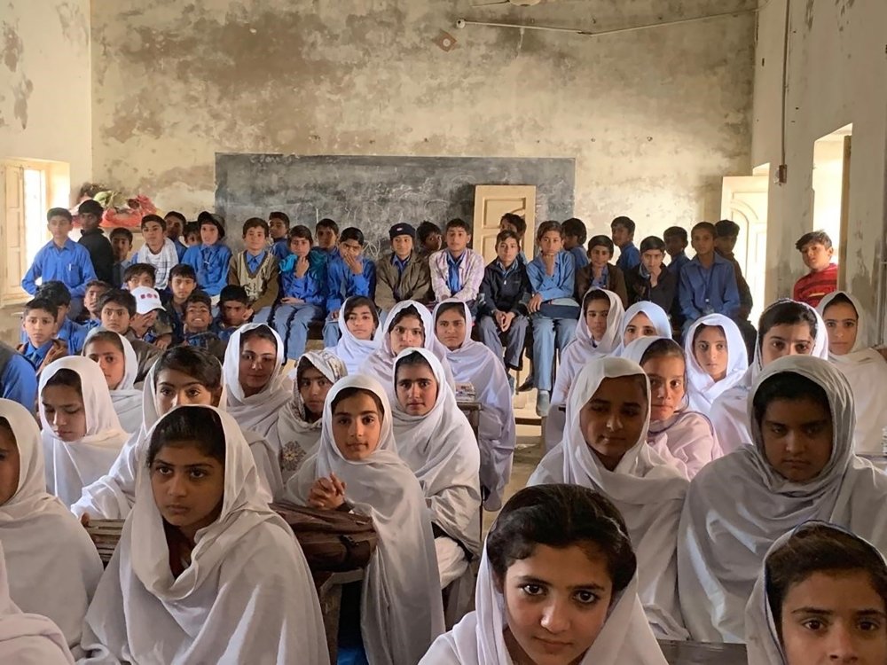 Pakistani children packed into an overcrowded schoolroom.